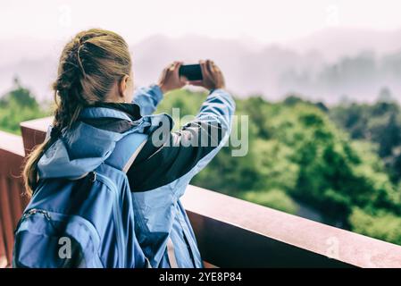 Giovane turista che scatta foto di montagne. Immagine tonificata Foto Stock