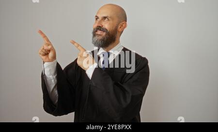 Bell'ispanico che punta mentre indossa un abito nero e una cravatta blu su sfondo bianco con un'espressione sicura Foto Stock