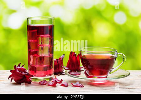 Tazza di tè caldo all'ibisco e la stessa bevanda fredda in bicchiere Foto Stock