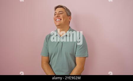 Bel giovane sorridente su sfondo rosa isolato in un ritratto che indossa una polo verde Foto Stock