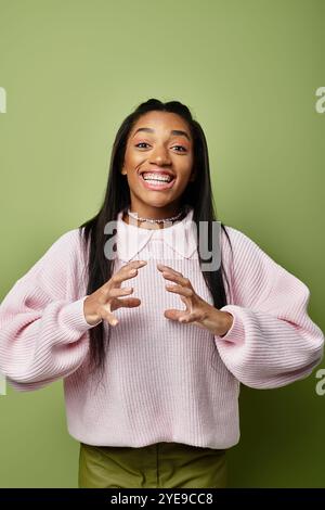 Una giovane donna con eleganti abiti autunnali mostra la sua felicità con un gesto animato. Foto Stock