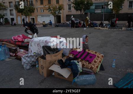 Beirut, Libano. 27 ottobre 2024. Si vede una donna seduta accanto ai suoi effetti personali per la strada di Beirut. Mentre la guerra tra Israele e Hezbollah continua in Libano, più di 1, 2 milioni di persone sono state colpite e sfollate dalle loro case, una cifra secondo le autorità libanesi. I rifugi in diverse città sono saturi e molti che non hanno mezzi finanziari hanno optato per vivere per strada. (Foto di Ashley Chan/SOPA Images/Sipa USA) credito: SIPA USA/Alamy Live News Foto Stock