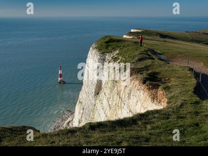 Uomo che guarda al faro di Beachy Head a Beachy Head, vicino a Eastbourne, South Downs National Park, East Sussex, Inghilterra, Regno Unito Foto Stock