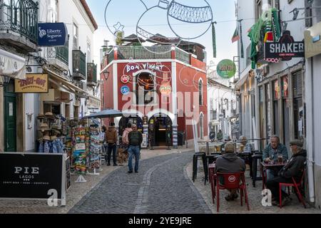 Scena di strada con negozi, caffetterie e decorazioni natalizie nella città di Lagos, Portogallo. Lagos è una città nella regione meridionale dell'Algarve. È sapere... Foto Stock