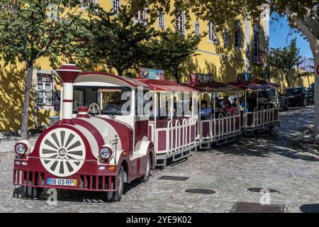 Treno turistico che guida i turisti per visitare le strade di Tavira in Portogallo; Tavira, Faro, Portogallo Foto Stock