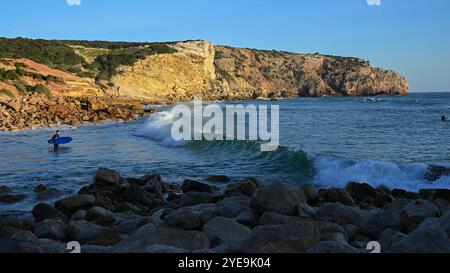 Surfisti pronti a prendere un'onda alla destinazione del surf Praia do Zavial, a Sagres, nella regione dell'Algarve, Portogallo; Raposeira, Faro, Portogallo Foto Stock