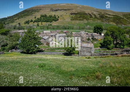 Il villaggio di Thwaite, sostenuto da Kisdon Hill in estate, Swaledale, Yorkshire Dales National Park, Yorkshire, Inghilterra, Regno Unito Foto Stock