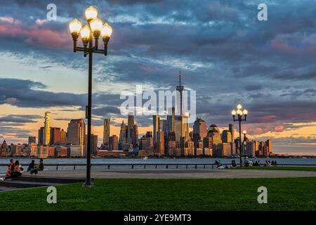 Skyline di Lower Manhattan al tramonto visto dal Pier A Park/Hoboken Riverside Park nel New Jersey, Stati Uniti; Hoboken, New Jersey, Stati Uniti d'America Foto Stock