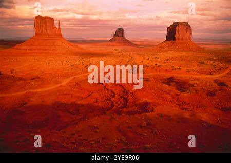 Monument Valley con luce calda al tramonto e tre corone (West Mitten Butte, East Mitten Butte e Merrick Butte), Arizona, USA Foto Stock