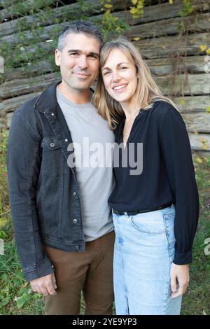 Ritratto di una coppia sposata sorridente e in piedi di fronte a un edificio in legno nella Beckwith Township a Carleton Place nella Ottawa Valley Foto Stock