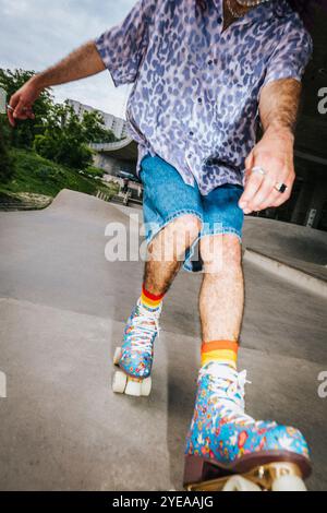 Vista ad angolo basso del pattinaggio a rotelle su strada di passaggio Foto Stock