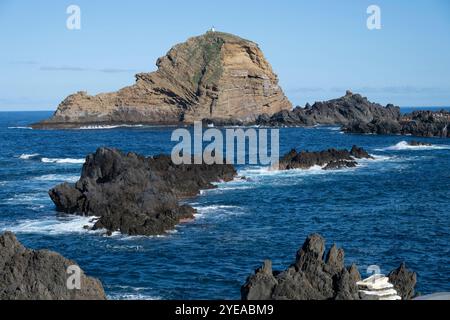 Faro di Porto Moniz in cima all'isola Mole lungo la costa della città costiera di Porto Moniz sull'isola di Madiera, Portogallo Foto Stock