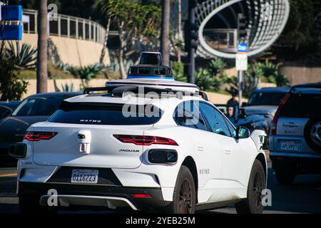 Un taxi auto a guida autonoma a Santa Monica su Ter Road che controlla se stesso nel traffico pesante con pedoni Foto Stock