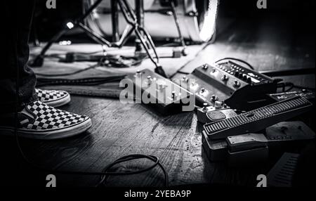 Il chitarrista pedalboard su un palco da concerto dal vivo accanto ai suoi piedi. Un classico concerto rock intimo. Foto Stock