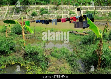 I residenti utilizzano la terra di sedimentazione nei flussi di fiume secco come luogo per asciugare temporaneamente i vestiti. Foto Stock