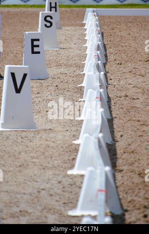 Primo piano della recinzione bianca e dei marcatori delle lettere sul ring durante una gara di dressage Horse Show. Foto Stock