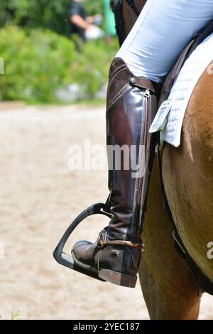 Un primo piano di gamba, stivale e staffa di un cavaliere dressage. Foto Stock