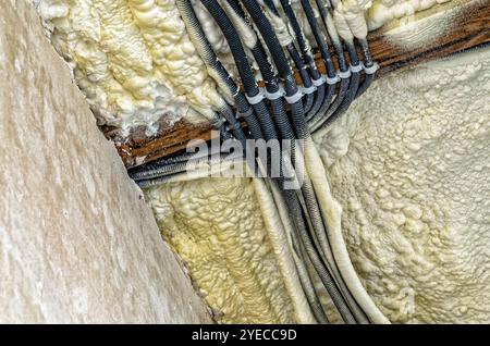 Costruzione di una nuova casa. Vista di pareti in calcestruzzo, soffitto con tubi isolanti, rivestiti in schiuma Foto Stock