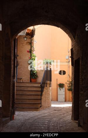 Vista attraverso un arco lungo una stretta strada secondaria in una città vecchia Foto Stock