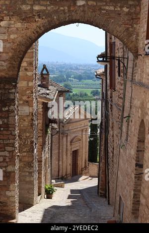 Vista attraverso un arco lungo una stretta strada secondaria in una città vecchia Foto Stock