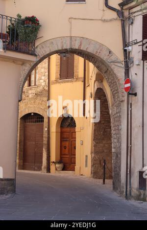 Vista attraverso un arco lungo una stretta strada secondaria in una città vecchia Foto Stock