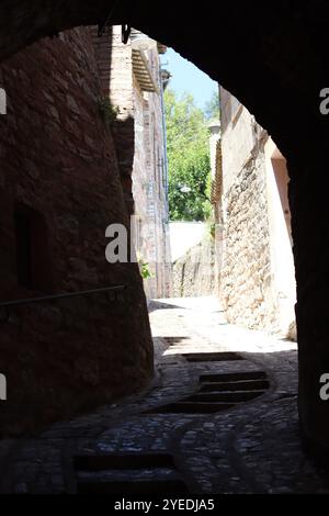 Vista attraverso un arco lungo una stretta strada secondaria in una città vecchia Foto Stock