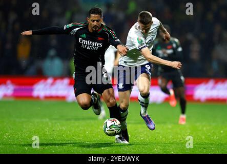 William Saliba (a sinistra) dell'Arsenal e Emil Riis Jakobsen del Preston North End si battono per il pallone durante il quarto turno della Carabao Cup a Deepdale, Preston. Data foto: Mercoledì 30 ottobre 2024. Foto Stock