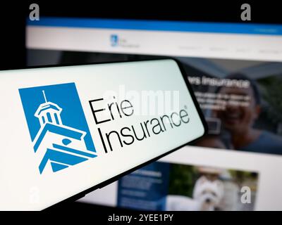 Cellulare con logo della società finanziaria americana Erie Insurance Group sullo schermo davanti al sito web. Mettere a fuoco la parte centrale sinistra del display del telefono. Foto Stock