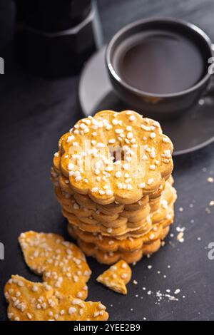 Biscotti dolci a forma di fiore. Gustosi biscotti su un tavolo nero. Foto Stock