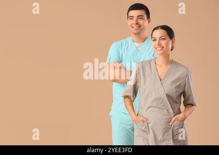 Massaggiatori sorridenti sullo sfondo beige Foto Stock