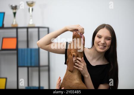 Un momento giocoso e gioioso condiviso tra una giovane donna e il suo adorabile Loving Dog oggi Foto Stock