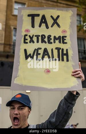 Londra, Schiedam, Regno Unito. 30 ottobre 2024. Un manifestante ha un cartello con la scritta "Tax Extreme Rich". Il 30 ottobre 2024, l'annuncio del governo laburista britannico del suo primo bilancio nazionale è stato accolto con proteste a Londra. Alle 11:00, i cittadini del Regno Unito si sono riuniti al 10 di Downing Street. Una volta che il bilancio era stato letto intorno alle 12:00, i manifestanti si trasferirono alla camera del Parlamento al Palazzo di Westminster. (Credit Image: © James Petermeier/ZUMA Press Wire) SOLO PER USO EDITORIALE! Non per USO commerciale! Foto Stock