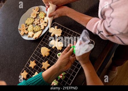 Decorare insieme i biscotti di natale, amiche anziane, a casa Foto Stock