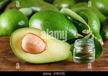Avocado verde maturo fresco e olio di avocado naturale. Centro benessere Foto Stock
