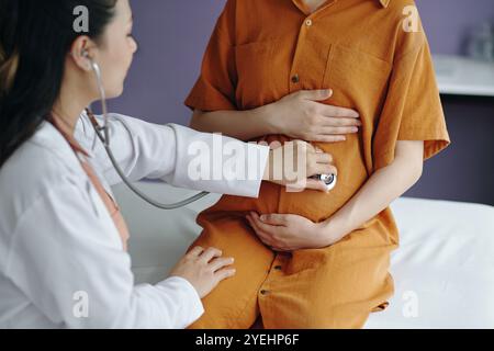 Esame della paziente in gravidanza con stetoscopio nella stanza dell'ospedale Foto Stock