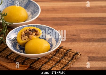 Panino di patate dolci fatto in casa con carne di maiale macinata, funghi e farciture di bambù tritate all'interno in una ciotola su fondo di legno. Foto Stock