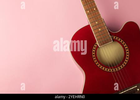 Dettaglio della chitarra rossa su sfondo rosa. Spazio per il testo. Vista dall'alto Foto Stock