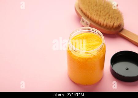 Pasta di zucchero fatta a mano con olio di Argan. Strofinare con la spazzola massaggiante su sfondo rosa. Vista dall'alto Foto Stock