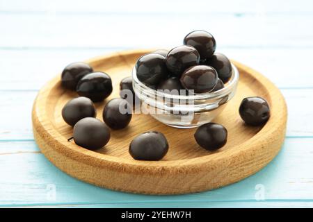 Olive nere con limone su piatto di legno su fondo di legno blu. Vista dall'alto Foto Stock