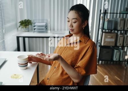 Giovane donna incinta che si gode un momento rilassante in ambiente ufficio Foto Stock