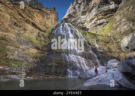 Hikker womann che guarda la cascata dell'Horsetail nel parco nazionale di Ordesa, Pirenei, Spagna, Europa Foto Stock