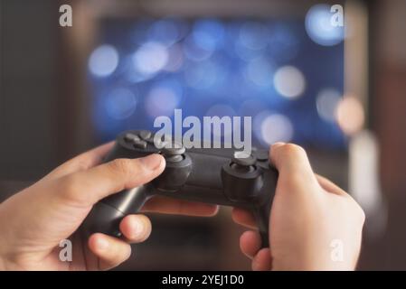 Man tenere un game pad nella parte anteriore dello schermo tv Foto Stock