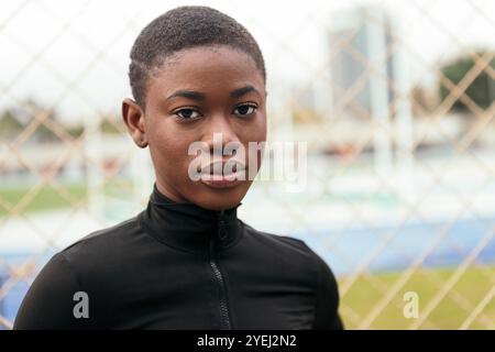 donna etnica con capelli corti che guarda la macchina fotografica Foto Stock
