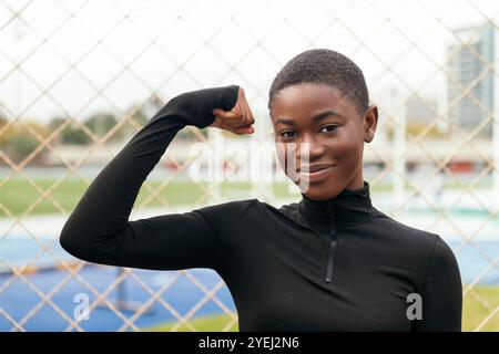 donna afroamericana che mostra muscoli Foto Stock
