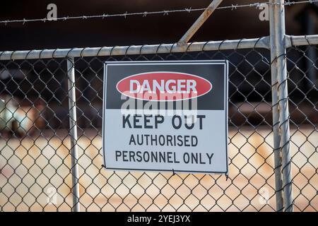 Questa fotografia mostra un primo piano di un cartello "pericolo - divieto di accesso - solo personale autorizzato" apposto su una recinzione a catena. Foto Stock