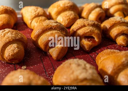 Croissant o bagel con marmellata sul piano di produzione. Mini panetteria, pasticcini squisiti. Foto di alta qualità Foto Stock