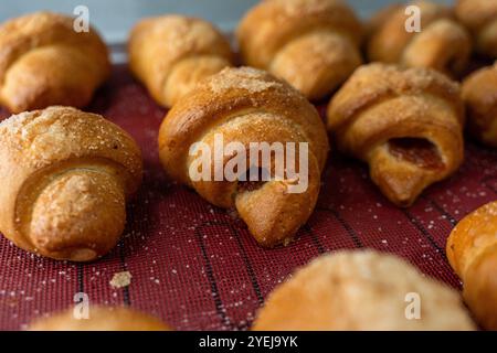 Croissant o bagel con marmellata sul piano di produzione. Mini panetteria, pasticcini squisiti. Foto di alta qualità Foto Stock