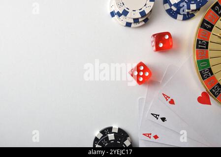 Lo sfondo dei giochi del casinò è isolato su un tavolo bianco con carte da gioco, fiches e dadi per giocare a vari giochi d'azzardo. Vista dall'alto. Foto Stock