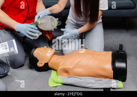 Donna che tiene il sacchetto di respirazione Ambu bag.dimostrazione CPR Cardiopolmonare rianimazione procedura medica di formazione sulla bambola CPR nella classe.Paramedic dem Foto Stock