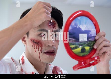 Bangkok, Thailandia. 31 ottobre 2024. Un membro del personale ha applicato un trucco horror durante un viaggio di donazione di sangue di Halloween presso il National Blood Center della società della Croce Rossa tailandese a Bangkok. Il personale del National Blood Center indossava costumi fantasma per celebrare il festival di Halloween e mirava a incoraggiare i donatori a donare il loro sangue come parte di una sanguinosa campagna di Halloween della società della Croce Rossa tailandese. Credito: SOPA Images Limited/Alamy Live News Foto Stock